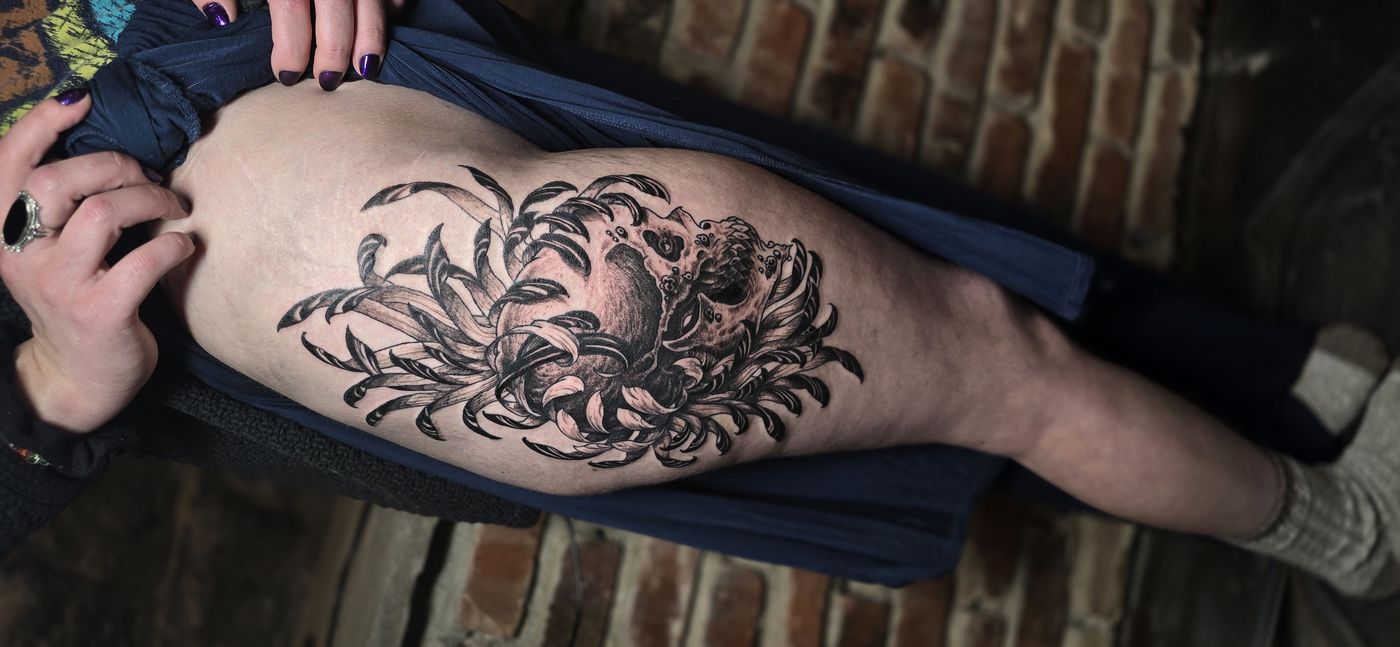 Chrysanthemum and crab blackwork thigh tattoo