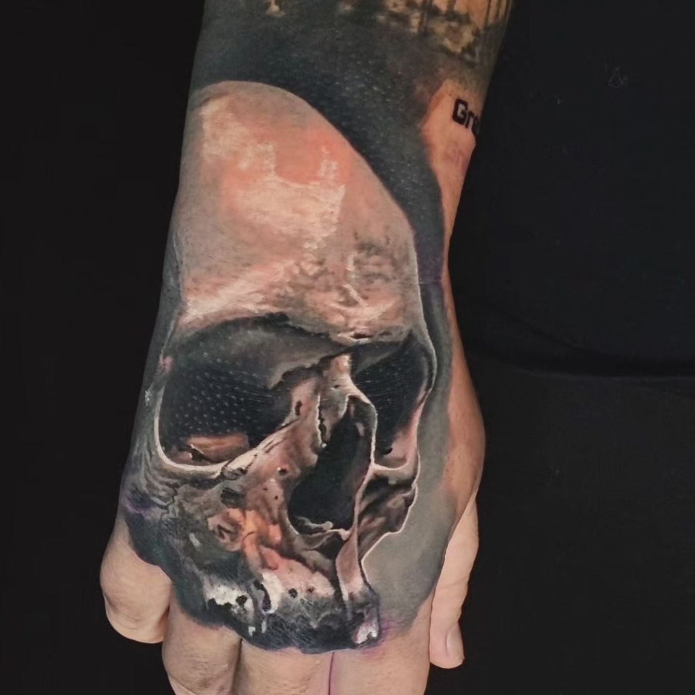 Black and grey skull hand tattoo